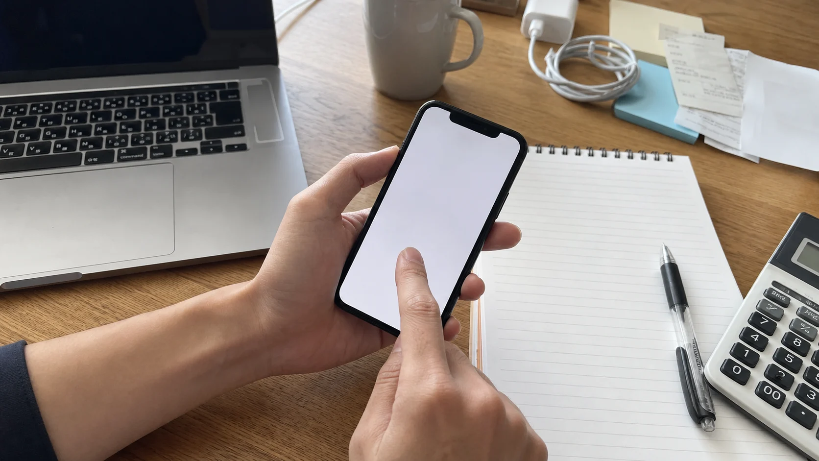 スマホ料金と家計メモを確認している手元