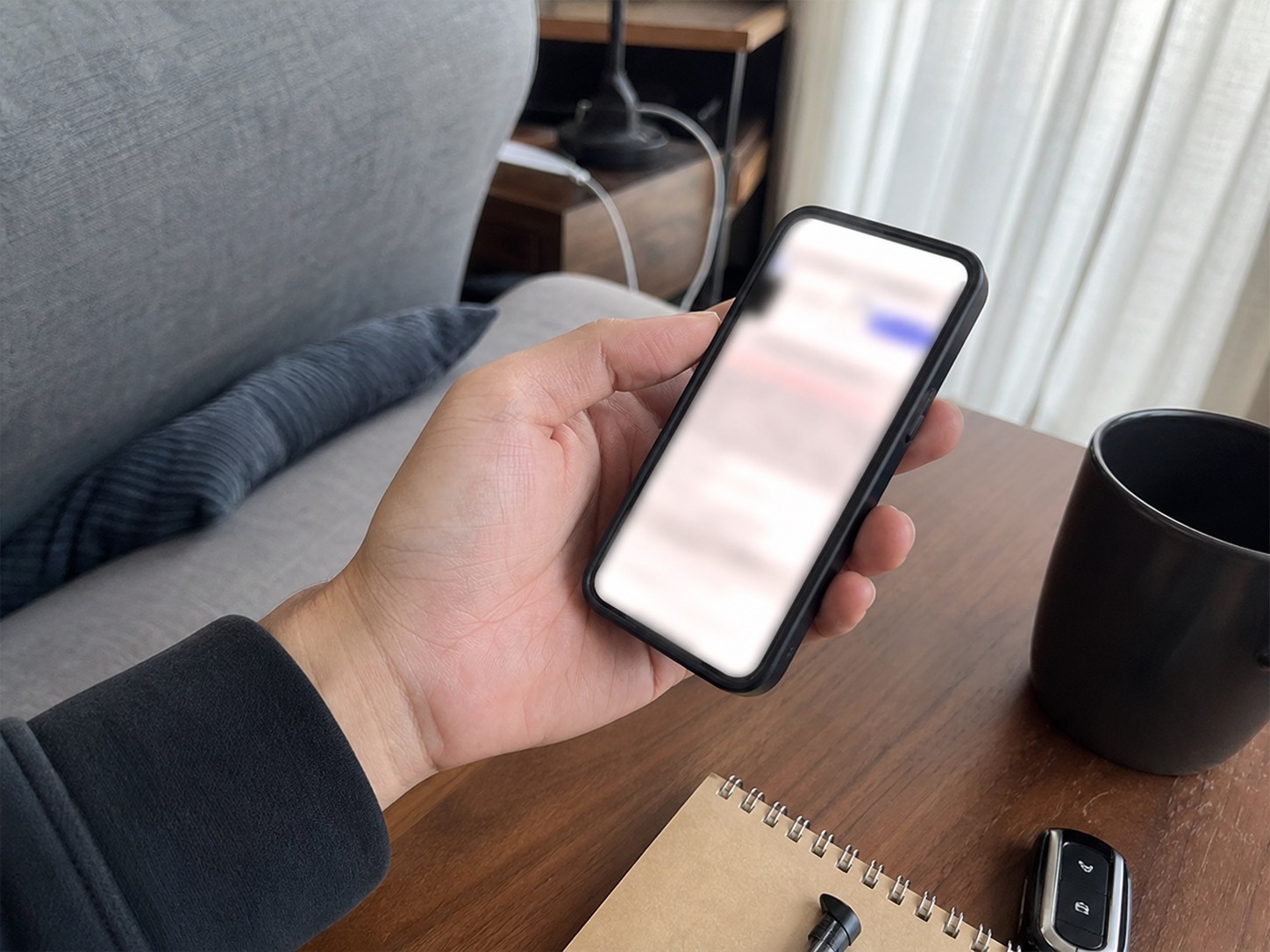 スマートフォンで紹介リンクの条件を確認している手元